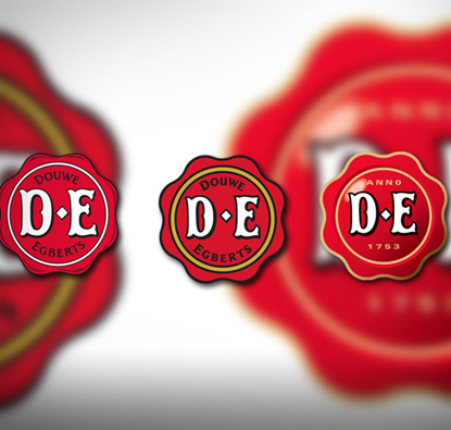 Verschillende logo's van Douwe Egberts die over de tijd veranderd zijn, naast elkaar afgebeeld.