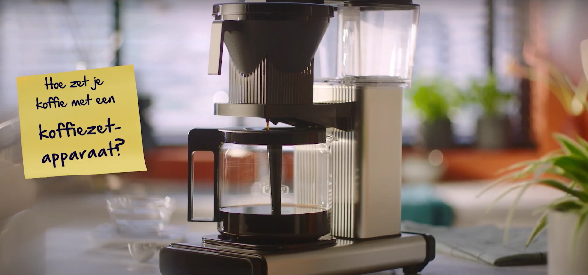 Ouderwets koffiezetapparaat met een gele memo met daarop de tekst: Hoe zet je koffie met een koffiezetapparaat?