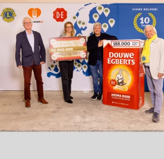 A group of people standing next to a cheque with a number on it and a giant package of Douwe Egberts Aroma Rood coffee.